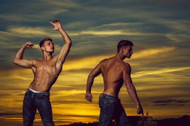 muscular men in sunset with boxes - Foto, imagen