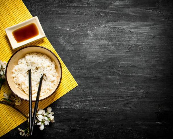 gekochter Reis mit Sojasauce und Kirschzweigen - Foto, Bild