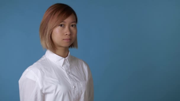 肖像画スタジオに青色の背景で若いアジア女性 - 映像、動画