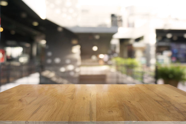 Lege donkere houten tafel voor abstracte onscherpe achtergrond  - Foto, afbeelding