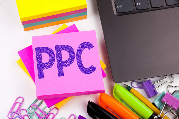 Writing text showing PPC - Pay per Click made in the office with surroundings such as laptop, marker, pen. Business concept for Internet SEO Money Workshop white background copy space - Photo, Image