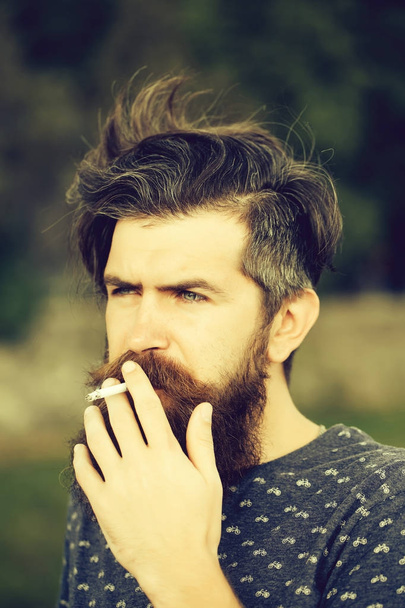 bearded man smoking cigarette outdoor - 写真・画像