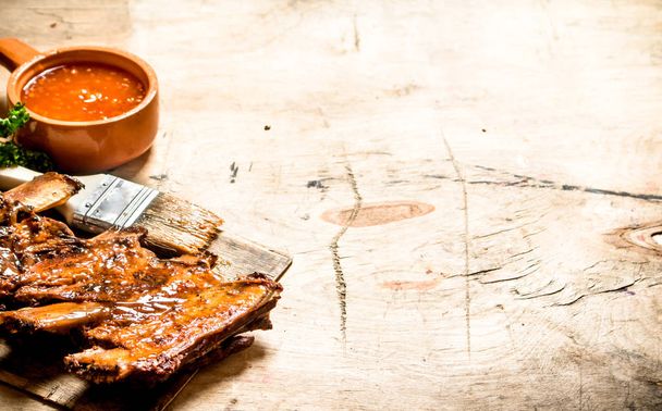 Smoked pork ribs with hot sauce and a brush. - Photo, Image