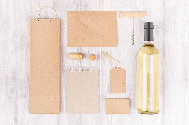 Corporate identity template for wine industry,  blank brown kraft packaging, stationery, merchandise set with bottle white wine on soft white wood background. - Фото, зображення