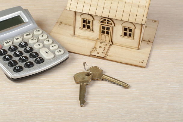 Strona główna oszczędności, koncepcja budżetu. Modelu dom, klucze i Kalkulator na stół drewniany office. - Zdjęcie, obraz