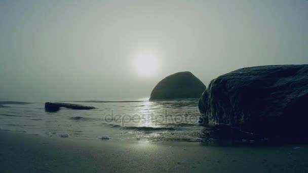 Κύματα της θάλασσας στην ομίχλη. Κύματα εκτοξεύεται με μπαλώματα του φωτός του ήλιου στην ομίχλη στην ακτή.  - Πλάνα, βίντεο