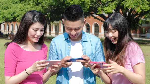  students using  phones outdoors  - Zdjęcie, obraz