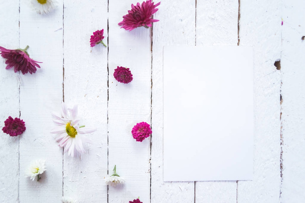 Multicolored flowers on a white wooden mocap background. - Foto, imagen