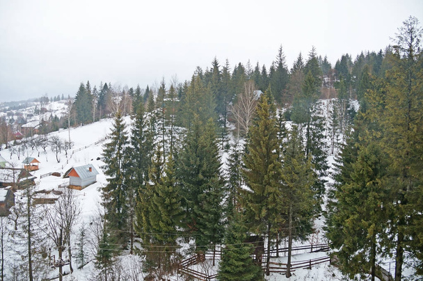 Der Winter hat das Bergdorf in den Karpaten der Ukraine eingehüllt. kleine Häuser in einem verschneiten Gebirgstal in den ukrainischen Karpaten. Winter in den ukrainischen Karpaten. - Foto, Bild