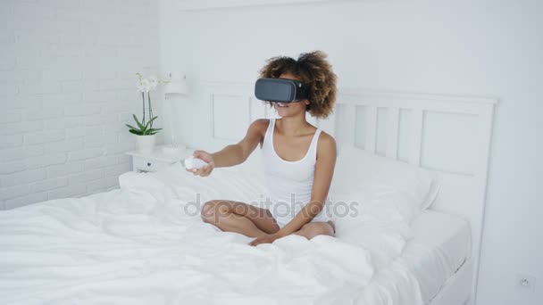 Content woman in VR glasses on bed - Imágenes, Vídeo