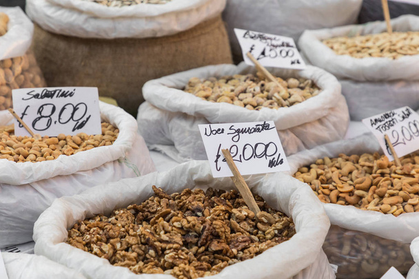 Many different colorful spices, nuts and dried fruits at market  - Foto, imagen