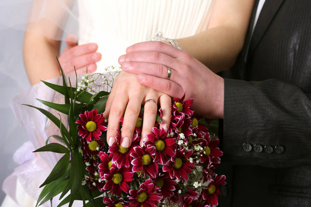 manos de la novia y el novio cerca del ramo de bodas
 - Foto, imagen