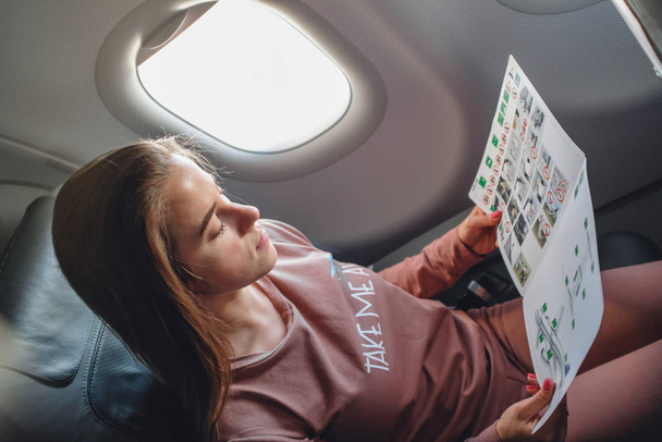 Girl is reading insructions in arplane - Фото, изображение