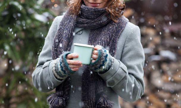 Frau holt Tasse mit heißem Glühwein auf Winterweihnachtsmarkt - Foto, Bild