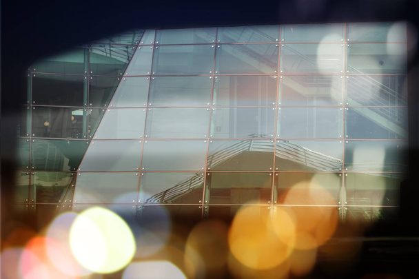 Abstraktes Geschäft moderne Stadt futuristische Architektur Hintergrund. Immobilienkonzept, Bewegungsunschärfe, Spiegelung in Glas der Hochhausfassade, getöntes blaues Bild mit Bokeh - Foto, Bild