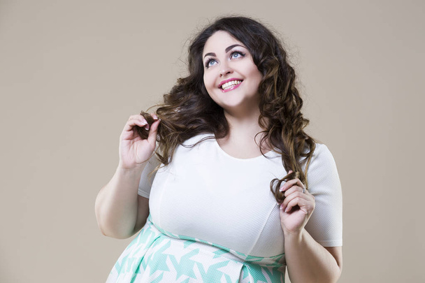 Happy plus size fashion model, sexy fat woman on beige background - 写真・画像