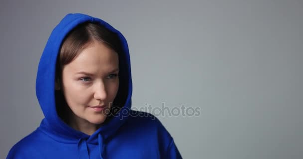 Frau in blauem Baumwollkapuzenpullover trinkt Wasser - Filmmaterial, Video