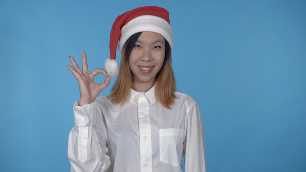 mooie Koreaanse vrouwelijke Kersttijd toont teken okey - Video