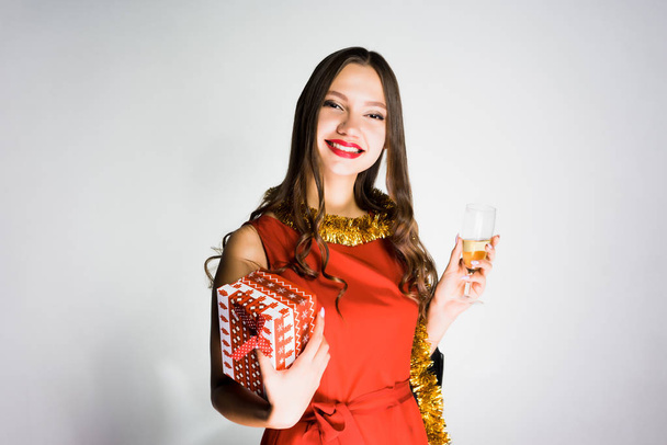 happy young girl in red dress rejoices in the new year of 2018, received a gift, holds a glass of champagne - Zdjęcie, obraz