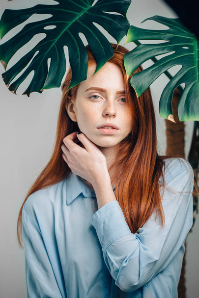 beautiful redhead girl cover with green leaves. - Foto, Imagem