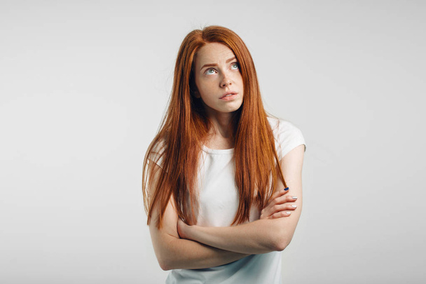 Portrait of redhead displeased girl with crossed arms and rollong eyes - Foto, Imagem