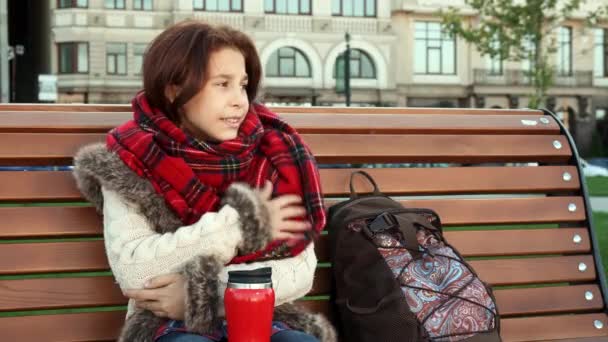 Bella ragazza si sente freddo seduto sulla panchina
 - Filmati, video