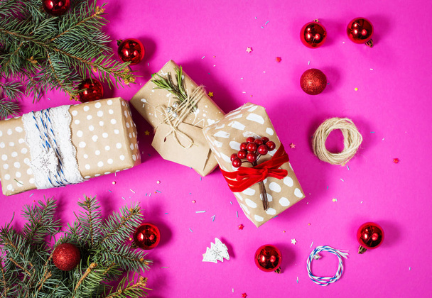 Christmas background with decorations and gift boxes on pink board. - Photo, Image