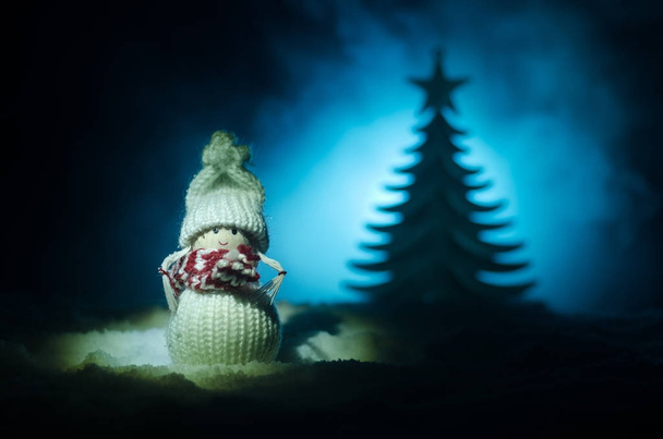Boneca Feliz Papai Noel na época de Natal com árvore e neve. Fundo bokeh colorido. Papai Noel e Feliz Natal modelo figura brinquedo em tom escuro
 - Foto, Imagem