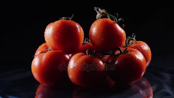 A lot of ripe fresh tomato lying on a black glass table and rotates around its axis. Close-up fresh vegetables. - Footage, Video