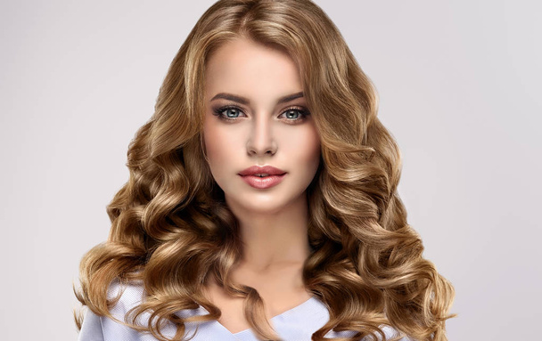 Brunette dívka s kudrnatými vlasy dlouhé a lesklé. Krásný model žena s kudrnatý účes. Péče a krásy vlasů - Fotografie, Obrázek
