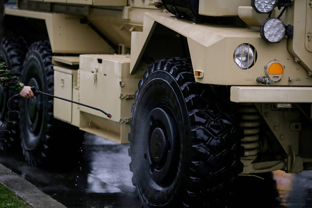Soldado lavando un vehículo blindado
 - Foto, imagen