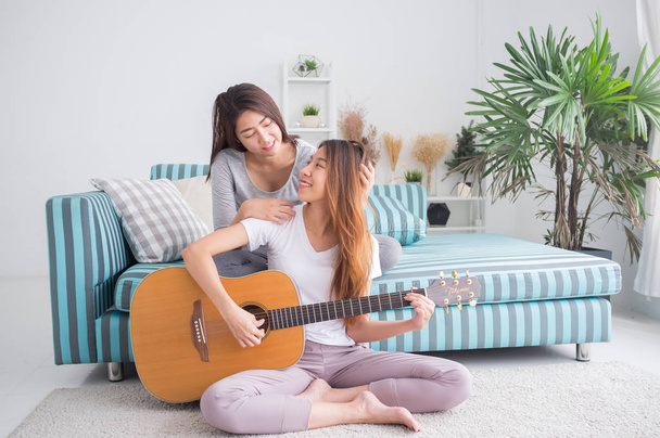 Lesbian couple together concept. Couple of young women playing g - Photo, Image
