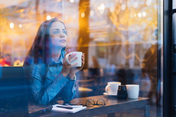 pensive young business lady working at a cafe, drinking coffee - Foto, Imagen