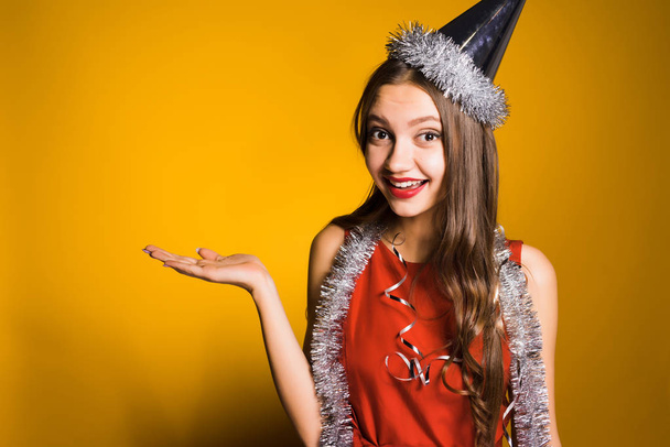 happy young girl celebrates the new year and christmas, on the neck a silver tinsel - Photo, image