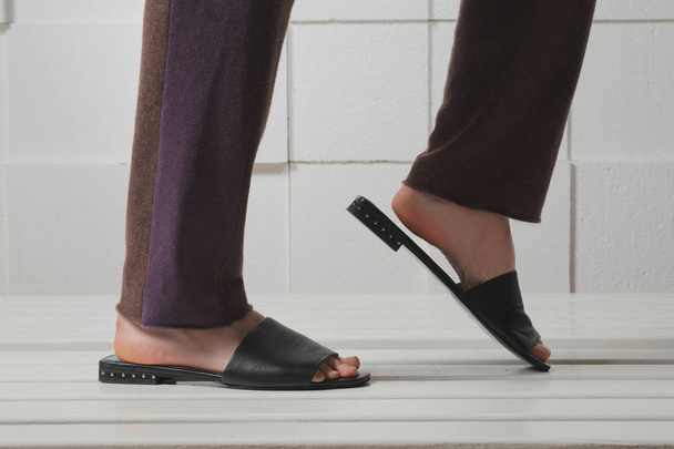 Female legs in leather slippers - Zdjęcie, obraz