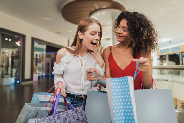 Girls are shopping at the mall. Sale in black Friday. Girls are shopping on a black Friday. - Foto, Imagem
