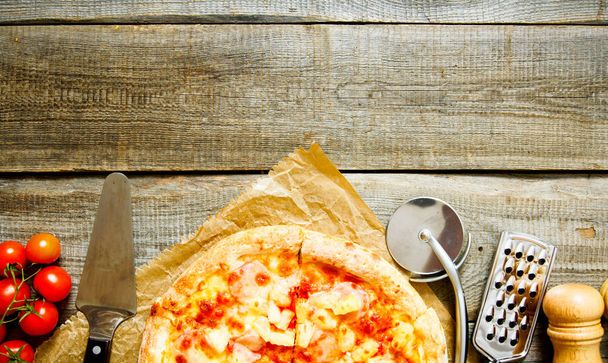 Tasty pizza and ingridients. On wooden background - Foto, afbeelding
