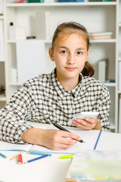 Teenage girl preparing for exams. Teenage girl doing homework . - Fotó, kép