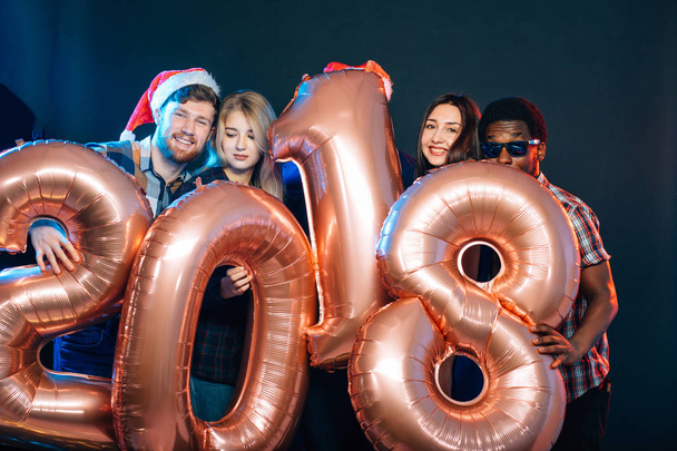 Happy smiling people holding golden number balloons, 2018 year symbol - Φωτογραφία, εικόνα