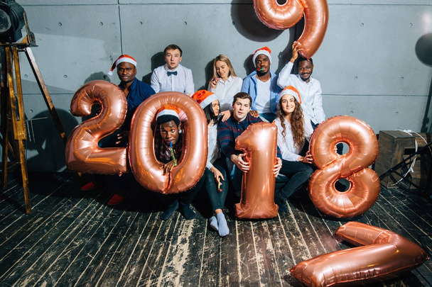 Happy smiling people holding golden number balloons, 2018 year symbol - Valokuva, kuva