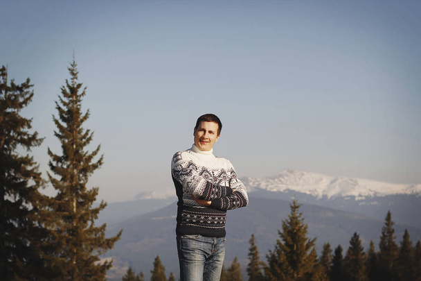 Young happy man standing on the top of mountain in snowy winter - Foto, Imagem