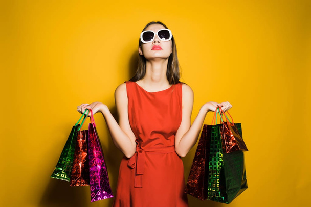 A young fashionable girl in sunglasses went shopping on a black Friday - Zdjęcie, obraz