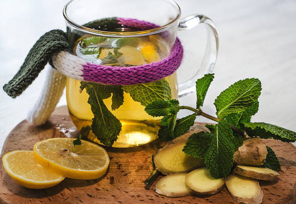 Горячий чай с имбирем, лимоном и мятой на белом фоне. Здоровый образ жизни, лечение простуды
 - Фото, изображение