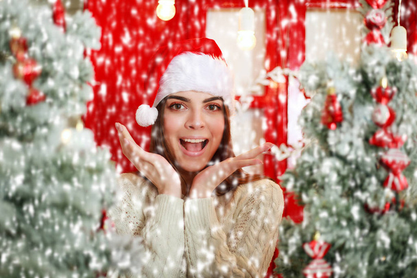 Happy and excited woman on snowfall background Christmas tree - Фото, изображение