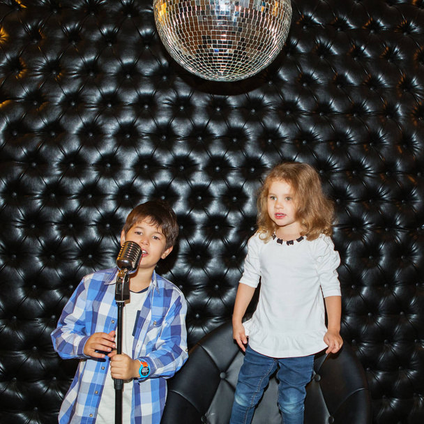 Bir raf üzerinde bir mikrofon ile küçük çocuk şarkı  - Fotoğraf, Görsel