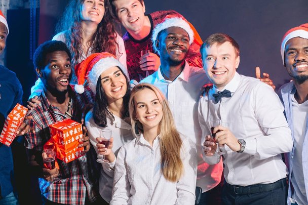 Group of beautiful young people in Santa hats looking a side - Foto, imagen