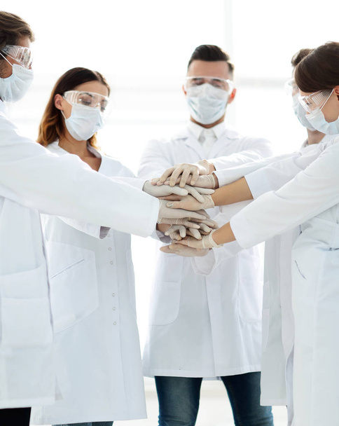 Foto de cerca de médicos apilando mano con compañeros de trabajo
 - Foto, Imagen