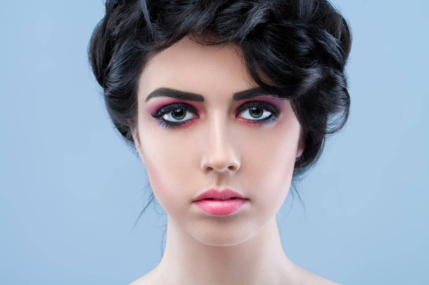 Closeup portrait of young beautiful girl with art makeup in a high fashion. Beauty vintage style, red lips make up at blue background. Vogue style portait. Hairstyle, skincare and cosmetics concept - Photo, Image