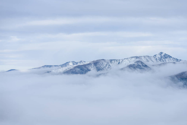 cumes de montanha no outono cobertos de névoa ou nuvens
 - Foto, Imagem