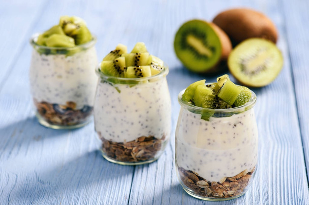 Yogurt with chia seeds, muesli and kiwi fruit. - Fotó, kép